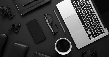 Business desktop concept. Mix of office supplies and gadgets on a black table background