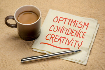 Wall Mural - optimism, confidence, creativity inspirational handwriting on a napkin with a cup of coffee, career, lifestyle and personal development concept