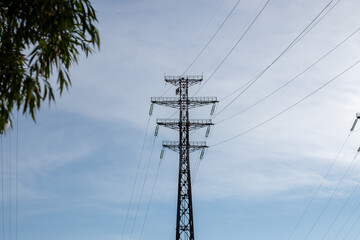 Power line with a tower on a background of blue sky.