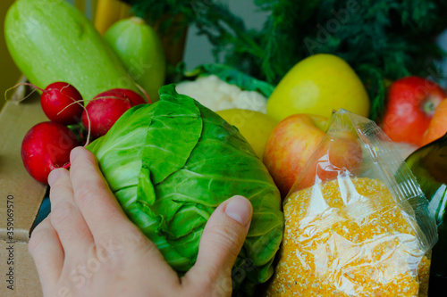 Support Food Banks During Coronavirus. COVID-19 Relief Funds and Donations. Volunteer in the Protective Medical Mask and Hand Gloves Holding Food Donation Box. Charity donations