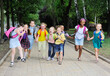 © Evgeniy Kalinovskiy - a group of school children of different races in colorful clothes with school bags and backpacks run to school against the background of green m Park. Back to school, knowledge day,