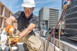 © spatesphoto - HVAC technician wearing PPE repairing a air conditioner