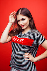 young pretty emitonal posing teenage girl on bright red background, happy smiling lifestyle people concept