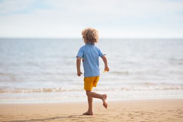 Wall Mural - Kids play on tropical beach. Sand and water toy.