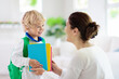 © famveldman - Child going back to school. Mother and kid.