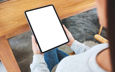 Top view mockup image of a woman holding black tablet pc with blank white desktop screen