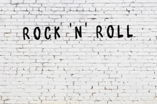 White Wall With Black Paint Inscription Rock 'n' Roll On It