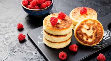 Wall Mural - Cottage cheese fritters or syrniki with fresh raspberries. Tasty dessert or sweet breakfast. Russian, Ukrainian cuisine food