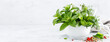 Bunch of aromatic herbs in mortar on kitchen table. Banner