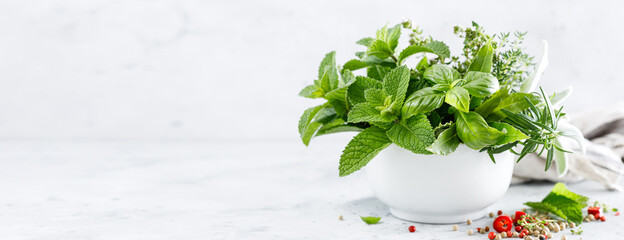 Canvas Print - Bunch of aromatic herbs in mortar on kitchen table. Banner