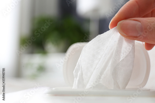 Woman taking wet wipe from pack on blurred background, closeup Tableau sur Toile