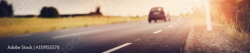 Fotografía asphalt road view with a car in countryside at beautiful sunset