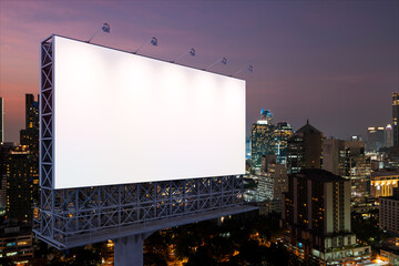 Blank white road billboard with Bangkok cityscape background at night time. Street advertising poster, mock up, 3D rendering. Side view. The concept of marketing communication to sell idea.