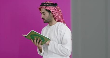 Wall Mural - Young arabian muslim man in traditional clothes praying during a ramadan feast at home