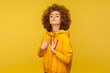 I am the best! Portrait of egoistic selfish curly-haired woman in urban style hoodie pointing herself and looking with arrogance, proud of success. indoor studio shot isolated on yellow background