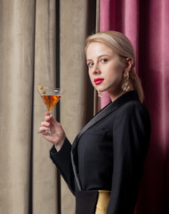 Poster - Beautiful blonde girl with cocktail on suede background