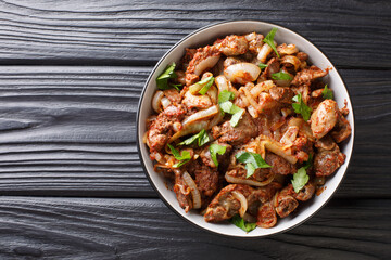 Armenian Tjvjik fried chicken offal liver, heart and stomachs with onions, tomatoes and spices close-up in a bowl. horizontal top view