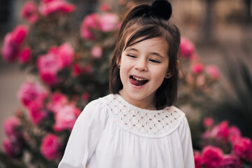 Wall Mural - Little kid girl 4-5 year old having fun posing over nature background closeup. Looking at camera. Summer season. Childhood.