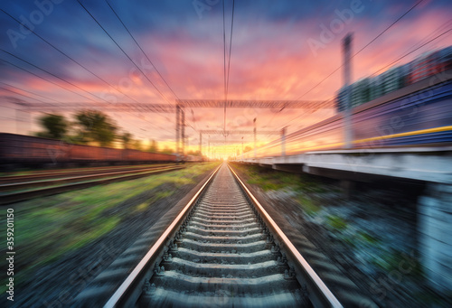 Cuadros en Lienzo Railroad and beautiful sky with clouds at sunset with motion blur effect in summer