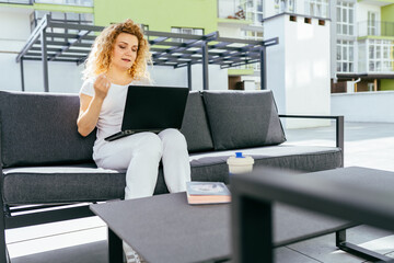 Wall Mural - Female freelancer working with laptop in summer taking notes in an agenda outdoors. People, lifestyle, freedom concept.