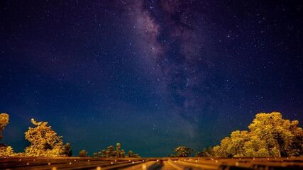 Wall Mural - milky way galaxy stars time lapse on night time, beautiful light of star on sky and clouds, tree and