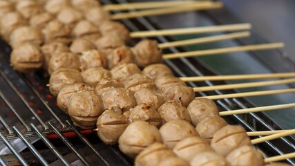 Wall Mural - Close up of Grill Meatballs on wooden skewers thai street food market