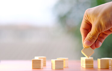 Businessman hand arranging wood cube stacking as step stair. Business concept growth success process and business word on table background and teamwork concept