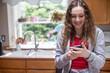 © Mat Hayward - Smiling teenage girl looking at social media on her mobile phone device