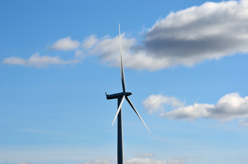 windmill on blue sky background with some clouds