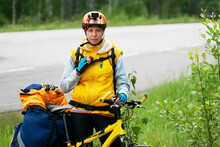 Young Woman In Sportive Clothes And Helmet Travelling Alone By Bike Wiith Action Camera, Pannier Bag And Drinking System. Solo Travell, Road Trip, Responsible Travelling And Hyper-local Travel Concept