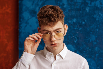 Fashionable young handsome man wearing trendy round yellow glasses. Copy, empty space for text