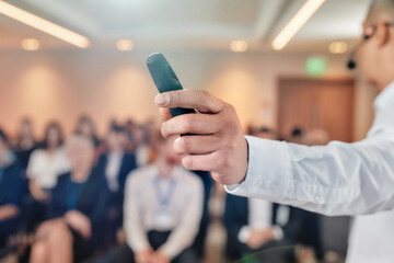 Wall Mural - Team Impact. Man hand holding laser pointer. Male speaker in suit giving a talk at business meeting, economic forum. Audience listening to him at the conference hall