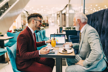  Two businessmen working together in modern cafe.