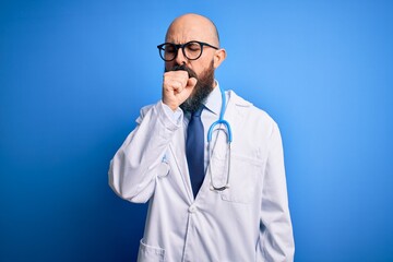 Canvas Print - Handsome bald doctor man with beard wearing glasses and stethoscope over blue background feeling unwell and coughing as symptom for cold or bronchitis. Health care concept.