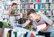 © JackF - portrait of  boy standing among bookshelves and searching for book in library