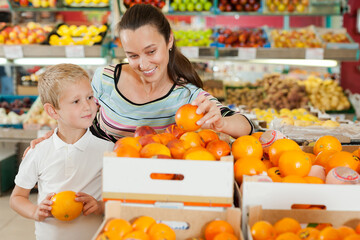 son with his mom choosing oranges