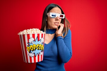 Wall Mural - Young blonde woman wearing 3d glasses and eating pack of popcorn watching a movie on cinema looking stressed and nervous with hands on mouth biting nails. Anxiety problem.