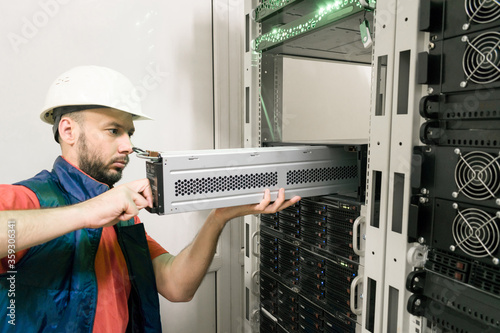 Cuadros en Lienzo An engineer installs a new battery pack into an uninterruptible power supply