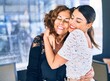 © Krakenimages.com - Beautiful mother and daughter smiling happy and confident. Standing with smile on face hugging at restaurant