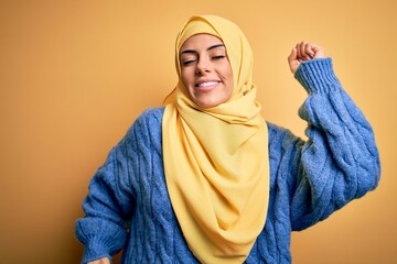 Sticker - Young beautiful brunette muslim woman wearing arab hijab over isolated yellow background stretching back, tired and relaxed, sleepy and yawning for early morning