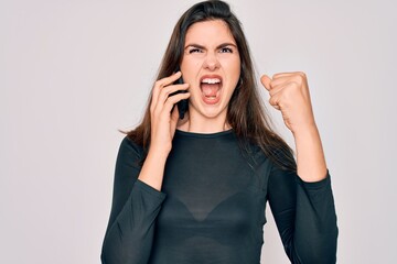 Young beautiful woman having a conversation talking on smartphone ove isolated background annoyed and frustrated shouting with anger, crazy and yelling with raised hand, anger concept