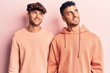 Sticker - Young gay couple wearing casual clothes looking away to side with smile on face, natural expression. laughing confident.