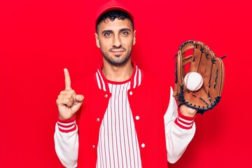 Poster - Young hispanic man wearing baseball uniform holding golve and ball smiling with an idea or question pointing finger with happy face, number one