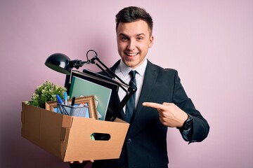 Wall Mural - Young handsome caucasian business man holding cardboard box unemployment fired from job very happy pointing with hand and finger