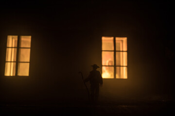 Wall Mural - Old house with a Ghost in the forest at night. Horror silhouette at the window. Old building in forest. Surreal lights. Horror Halloween concept