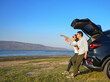© PK Studio - Young couple happy asian out on a road trip. Asian couple Man  and woman sitting on back of car travel to mountain and lake in holiday with car road trip