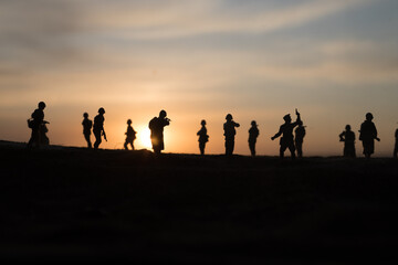 War Concept. Military silhouettes fighting scene on war fog sky background, World War Soldiers Silhouette Below Cloudy Skyline At sunset.