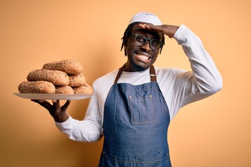 Sticker - Young african american bakery man holding tray with healthy wholemeal bread stressed with hand on head, shocked with shame and surprise face, angry and frustrated. Fear and upset for mistake.