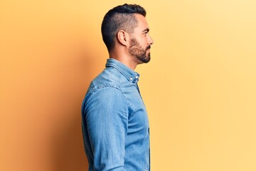 Young hispanic man wearing casual clothes looking to side, relax profile pose with natural face with confident smile.