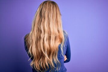 Poster - Young beautiful blonde woman wearing casual t-shirt over isolated purple background standing backwards looking away with crossed arms